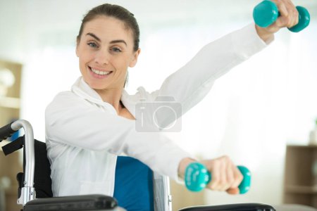 lady sitting in wheelchair working out with dumbbells