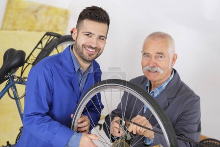 Zwei Männer reparieren gemeinsam ein Fahrrad