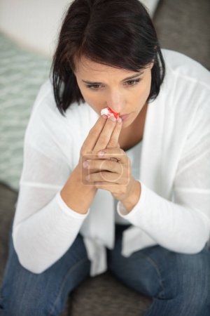 a young woman suffering from nose bleeding