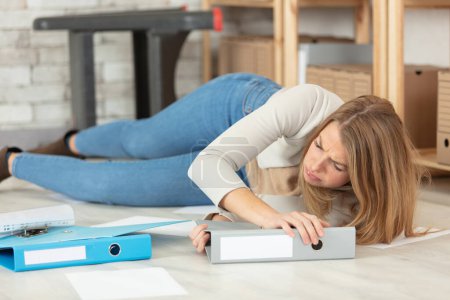 woman in the office stumbling with a pile of folders