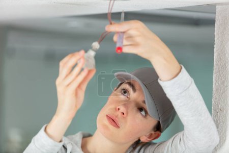 woman unscrew a light bulb