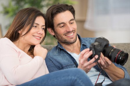 couple reviewing photographs on their camera sceen