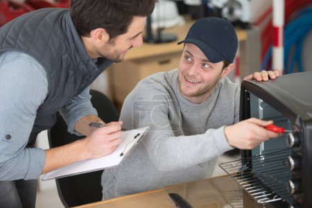 apprentice repairing appliance with his mentor