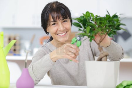 happy woman trimming a bonsai
