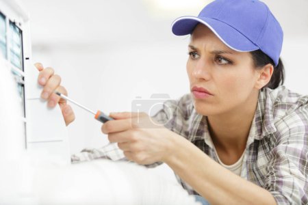 female engineer using screwdriver on an electrical appliance