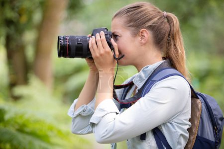 traveler photographing scenic view in forest