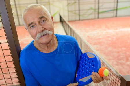 content senior male tennis player after training
