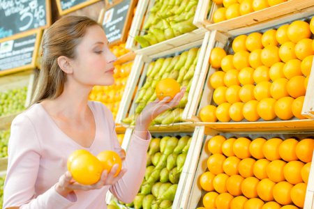 Dame hält Orangen im Gemüsehändler