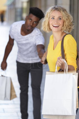 Jeune couple heureux avec des sacs à provisions dans la ville

