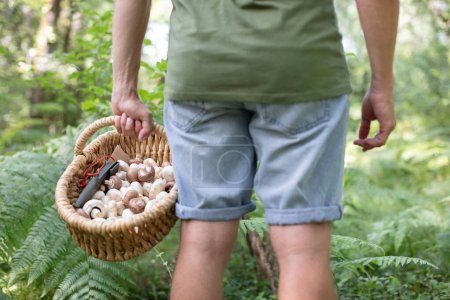 young man holds a basket of mushrooms