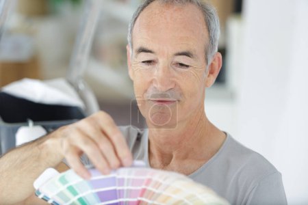 Anciano sosteniendo una muestra de color
