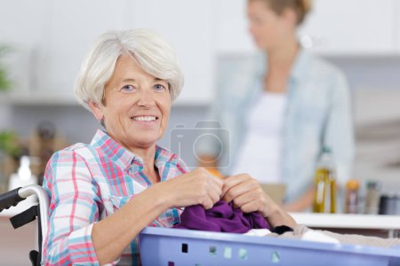 elderly woman holding laundry basket