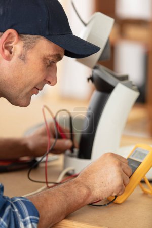 repairman testing an appliance with a multimeter