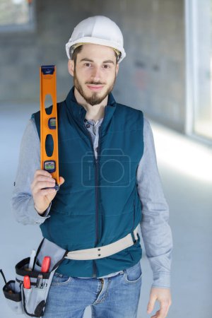onstruction worker holding levelling tool