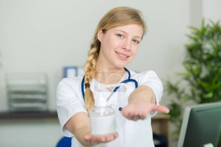 female nurse showing antibacterial hand gel