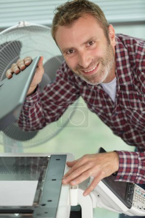 Mann nach Reparatur einer Druckmaschine glücklich