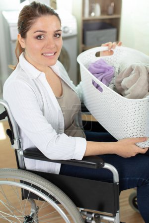 handicapé jeune femme portant panier pour faire la lessive
