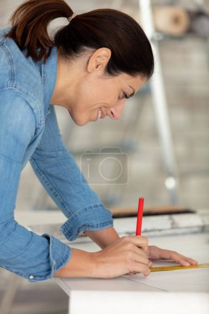 mujer tomando la medición de fondo de pantalla en un nuevo hogar