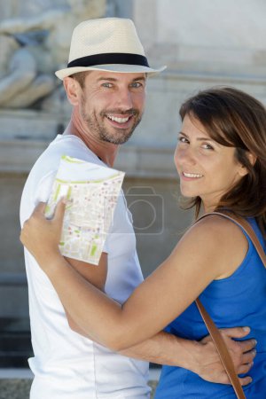 couple posing while holding a map