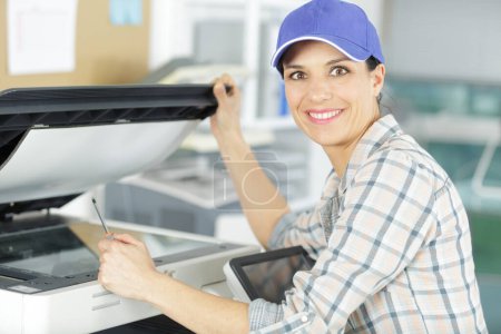 a happy technician repairing photocopier