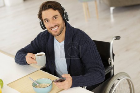 Behinderter Mann mit Kopfhörer hält Kaffee