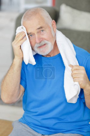 homme âgé essuyant la transpiration après avoir travaillé