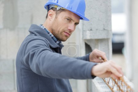ingeniero haciendo una comprobación de nivel en la pared exterior