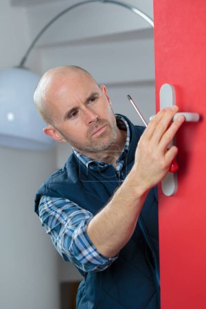 locksmith man fix the door with a screwdriver