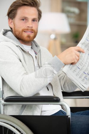 a man in wheelchair reading newspaper