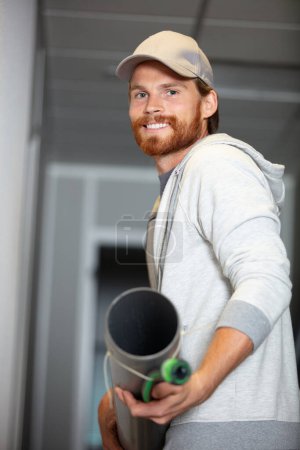 travailleur portant un tuyau sur le chantier de construction