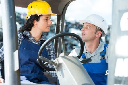 woman in forklift talking to foreman of construction company