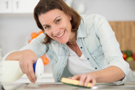 Lächelnde Frau klappert die Küchenspüle