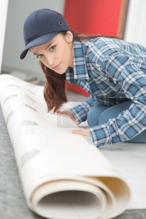 female worker unrolling carpet
