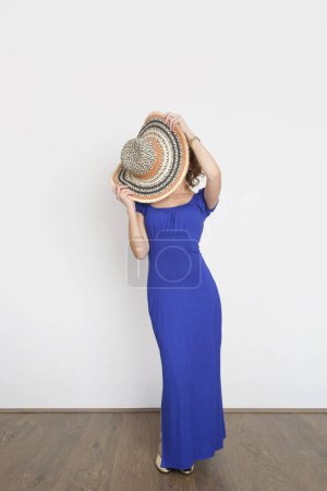 Foto de Estudio foto de la joven modelo femenina en vestido azul real de verano largo y sombrero de paja de ala ancha. - Imagen libre de derechos