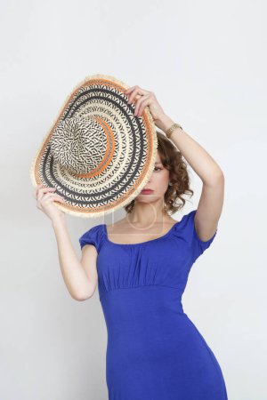 Foto de Estudio foto de la joven modelo femenina en vestido azul real de verano largo y sombrero de paja de ala ancha. - Imagen libre de derechos