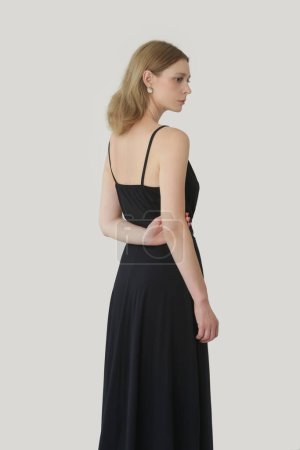 Téléchargez les photos : Serie of studio photos of young female model in comfortable yet stylish cotton black dress - en image libre de droit