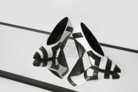 Photo for Women elegant pointy toe V cut mid kitten heels. Black and white leather shoes, product studio shot with reflexion - Royalty Free Image