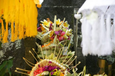 Foto de Canang sari, contenedor de bambú tejido con arroz, flores, incienso, dulces y frutas. Esta es una ofrenda a los Dioses, como un gesto de gratitud en Bali, Indonesia. - Imagen libre de derechos