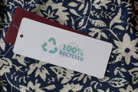 Téléchargez les photos : Gros plan de l'étiquette de vêtements avec icône de recyclage. Concept de produits de recyclage. Zéro déchet, production de suistainale, respect de l'environnement et concept de réutilisation - en image libre de droit