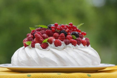 Téléchargez les photos : Pavlova cake - dessert à base de meringue avec fraises, mûres, framboises et feuilles de menthe - en image libre de droit
