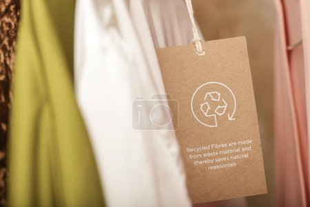Téléchargez les photos : Gros plan de l'étiquette de vêtements avec icône de recyclage. Concept de produits de recyclage. Zéro déchet, production de suistainale, respect de l'environnement et concept de réutilisation. - en image libre de droit
