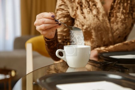 Photo for Woman adding sugar to hot drink - Royalty Free Image