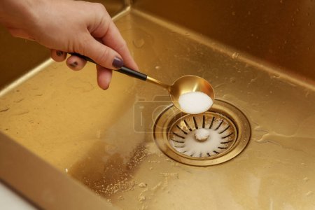 Cleaning kitchen sink with bakIng soda to keep sinks draining well and prevent clogs. Safe, effective, cheap, natural solution for clogged drains.