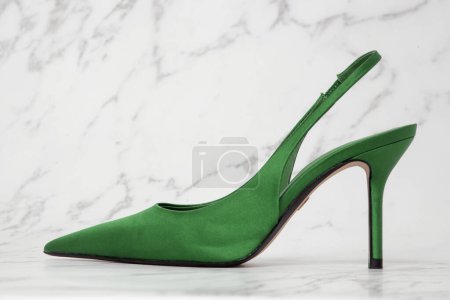 Creative studio shot of green satin slingbacks heels with the classy pointed toe, product photography