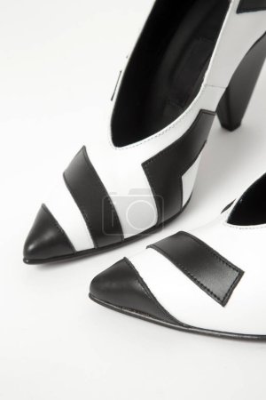 Photo for Women elegant pointy toe V cut mid kitten heels. Black and white leather shoes, product studio shot - Royalty Free Image