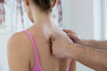 Frau in der Arztpraxis über Chiropraktik, Physiotherapie oder myodynamische Behandlung zur Behandlung und Vorbeugung von Muskel-Skelett-Problemen, zur Verringerung von Schmerzen und Muskelverspannungen.