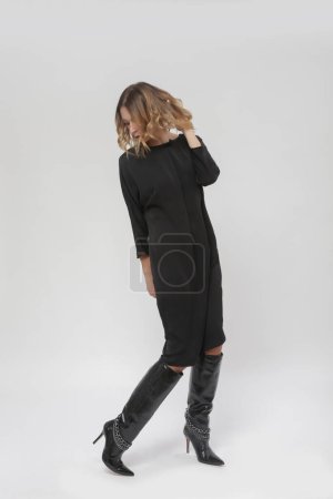 Serie de fotos de estudio de la joven modelo femenina en vestido negro atemporal