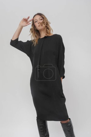 Serie von Studiofotos junger Models in zeitlosem schwarzen Kleid