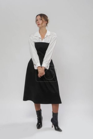 Série de photos studio de mannequin femme portant une chemise blanche boutonnée sous un haut tube noir Une robe midi ligne