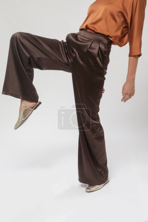 Série de photos studio de jeunes mannequins féminins portant une belle tenue simple, une blouse en satin de soie et un pantalon large